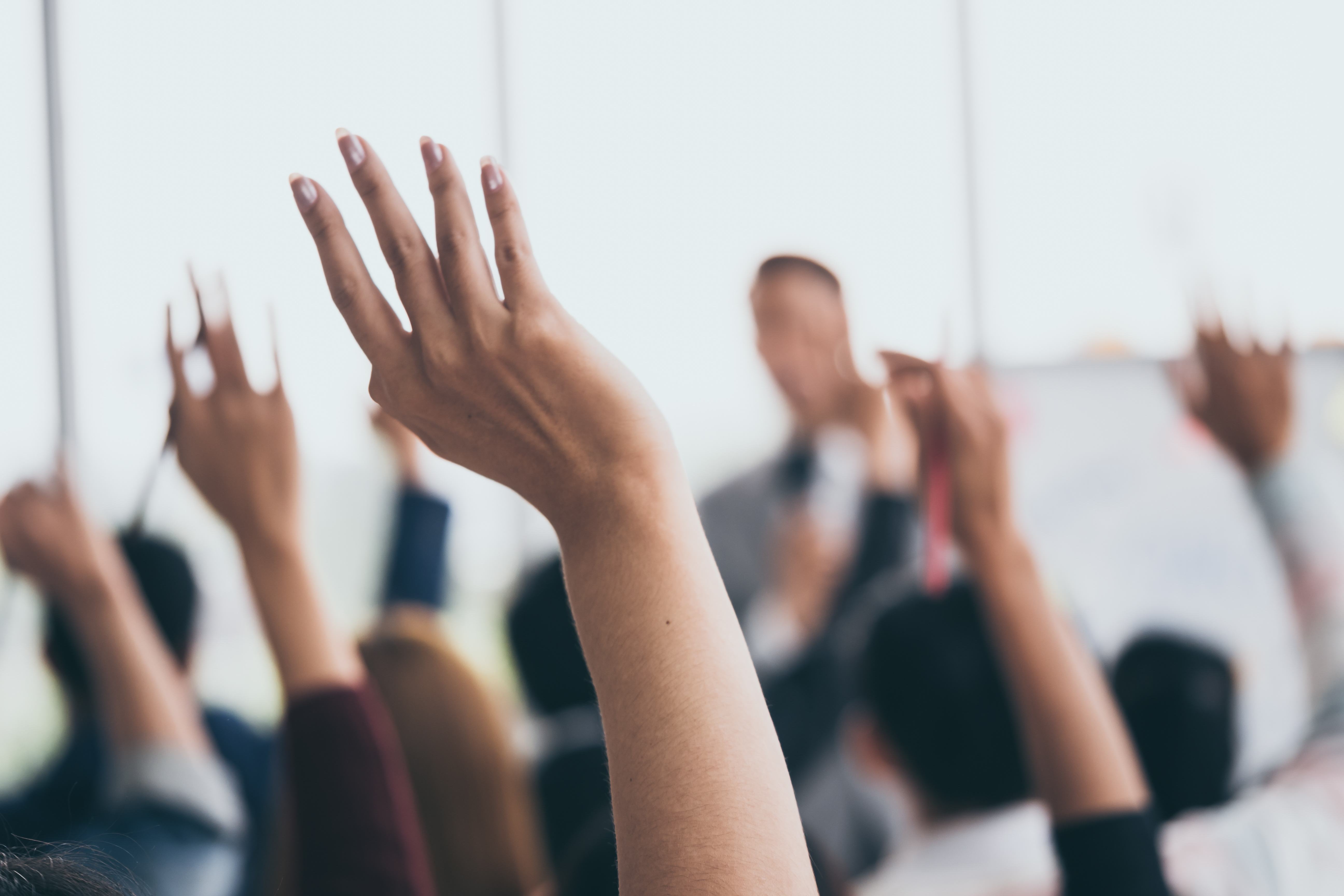 Group of people raising their hands.